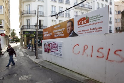 Un hombre pasa junto a un cartel electoral de un grupo independiente de Estepona.