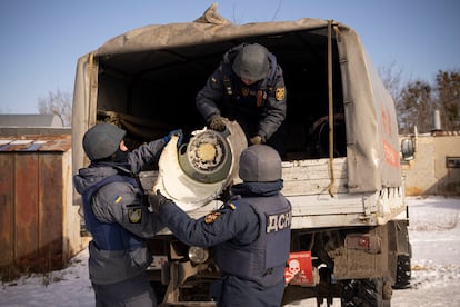 Miembros de los servicios de emergencia ucranios recuperan los restos de un misil lanzado por Rusia compatible con los sistemas de defensa antiaérea S-300, el viernes en Járkov.