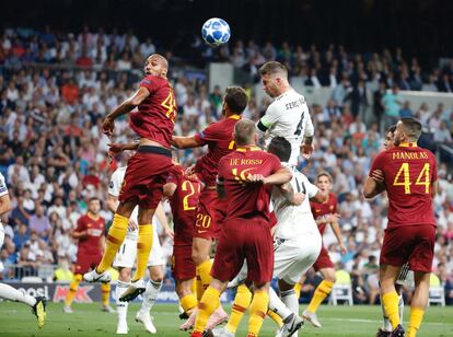 El defensa del Real Madrid Sergio Ramos cabecea el balón entre varios jugadores de la Roma.