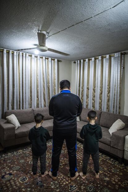 Hamza y Zakaria rezan con su padre Mohamed. Los niños viven junto a su padre, su madre y su pequeña hermana en un apartamento en una de las zonas más humildes de Amán.