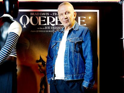 Gaultier posa junto al cartel de Querelle y uno de sus diseños inspirados en el filme.