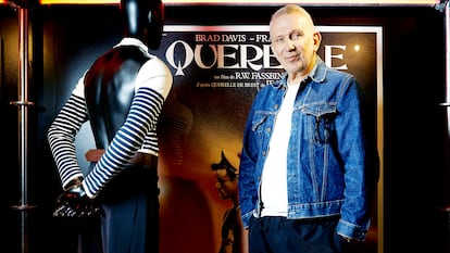Gaultier posa junto al cartel de Querelle y uno de sus diseños inspirados en el filme.