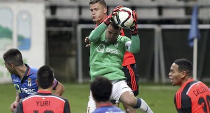 El guardameta del Real Oviedo, Esteban, captura el balón ante los jugadores de la Real Sociedad.