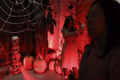 Una asistente a una fiesta de Halloween se hace un selfi junto a la decoración en Pekín (China), el 31 de octubre de 2018.
