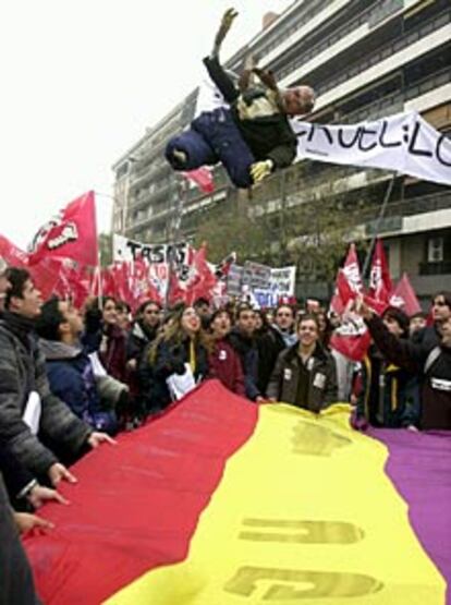 Durante el recorrido de una de las marchas por la calle Ferraz, un muñeco con el rostro de Aznar ha sido manteado con una bandera republicana. 
(EFE)