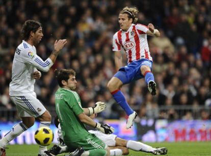 Forlán takes a shot at the goal, faced by Iker Casillas and Sergio Ramos.