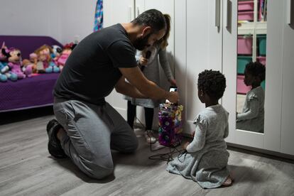 Paco, padre de acogida de Atu, de cuatro años, juega con ella y su otra hija, en su casa de El Hierro.