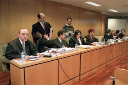 Uno de los vigilantes acusados (de pie, a la derecha), durante un receso del juicio que se inició ayer en la Audiencia.