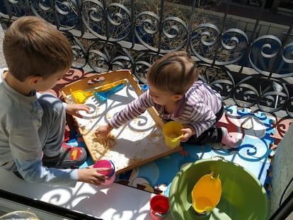 Dos hermanos jugando en su balcón de Chamberí, en Madrid.