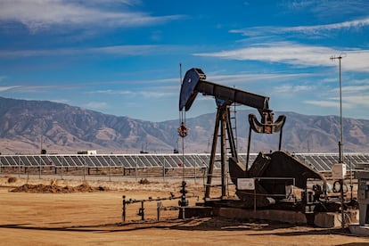 Paneles solares rodean un pozo de extracción de petróleo en California.