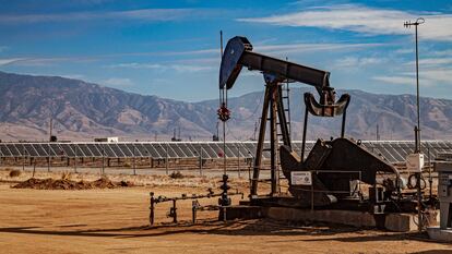 Paneles solares rodean un pozo de extracción de petróleo en California.