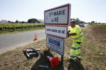 Un operario coloca un cartel en castellano cerca de la zona de acceso al campo de futbol Marcel Gaillard en Saint-Martin-de-Re, donde se entrenará la selección.