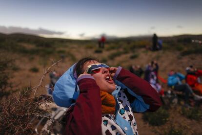 Una joven usa lentes protectores para observar el efecto "anillo de diamantes" en Piedra del Águila, Argentina. Ese efecto se ve cuando solo la superposición es casi completa y aparece como un anillo brillante alrededor de la silueta lunar.