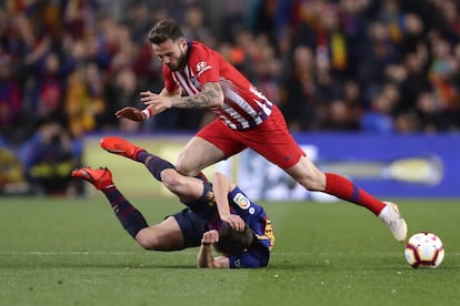 El mediocampista del Atlético Saul Níguez y Sergi Roberto luchan por un balón.