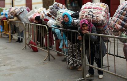 Porteadoras esperan su turno para cruzar la frontera entre Ceuta y Marruecos cargadas de bultos muy pesados.