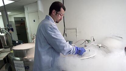 Un técnico de un banco de semen cierra un tanque de nitrógeno líquido que contiene esperma.