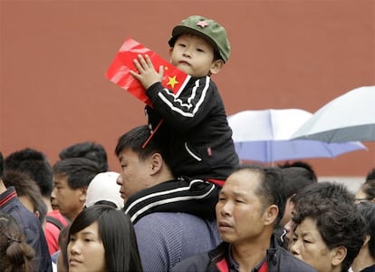 Un niño sentado sobre los hombros de su padre mientras hacen cola para entrar en la Ciudad Prohibida, durante los actos de conmemoración del Primero de Mayo.