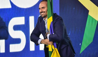 Eduardo Bolsonaro abraça bandeira do Brasil durante evento conservador em São Paulo, no dia 11 de outubro.