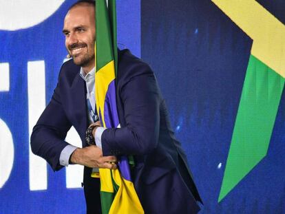 Eduardo Bolsonaro abraça bandeira do Brasil durante evento conservador em São Paulo, no dia 11 de outubro.