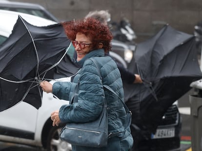 Una mujer se enfrenta a las fuertes rachas de viento, mientras camina por una calle del centro de Madrid este jueves.