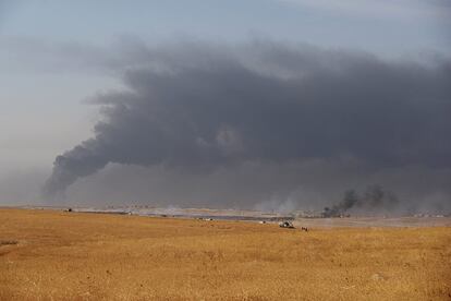 Combatientes peshmergas avanzan en le frente de Bashiqa ante una cortina de humo levantada por los yihadistas del ISIS que han quemado pozos de petróleo para dificultar la visión de las aviaciones de la coalición internacional. Este día tan sólo pudieron hacer cinco ataques aéreos.  

