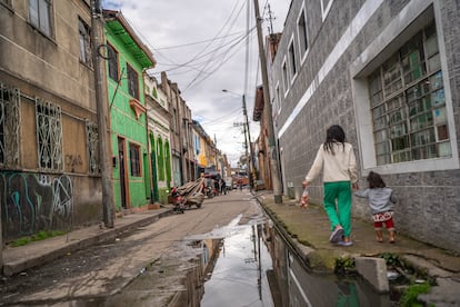 Dos niñas caminan por una calle del barrio San Bernardo en Bogotá, el 22 de mayo de 2025.