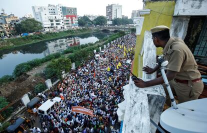 Un policía observa a los partidarios del Partido Bharatiya Janata (BJP) en una manifestación en apoyo a la nueva ley de ciudadanía, en Chennai (India).