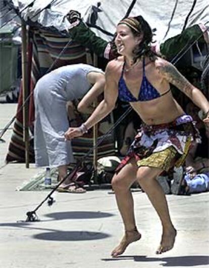 Una mujer baila ante uno de los puestos de demostración del Paseo Marítimo de Valencia.