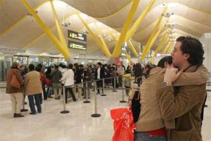 Una pareja se despide frente a una de las puertas de embarque de la nueva terminal de Madrid-Barajas.