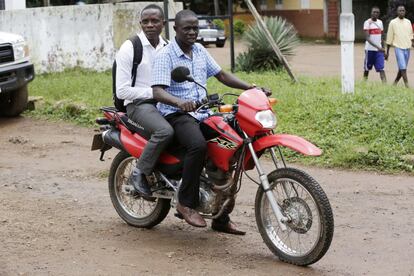 El técnico de laboratorio Mohamed SK Sesay sobrevivió al ébola, pero muchos de sus amigos murieron por culpa de la enfermedad. Él también asegura haber sufrido pérdida de visión y dolores musculares a raíz de la enfermedad. En la imagen, tomada el 11 de agosto, se pasea en moto con un amigo en la localidad de Kenema, en Sierra Leona.
