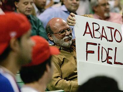 Imagen del espectador con el cartel contra Fidel Castro, durante el mundial de béisbol.