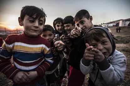 Niños yazidíes juegan con pistolas simuladas en el campo de refugiados de Essian.
