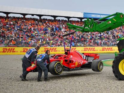 Los operarios retiran el Ferrari accidentado de Vettel
