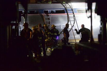 Bomberos trabajan en los restos del tren accidentado en Filadelfia. Hay al menos 50 personas heridas.