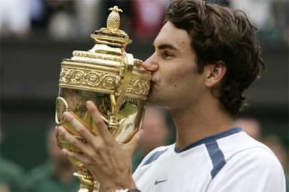 Roger Federer besa el tercer trofeo consecutivo que consigue en Wimbledon.