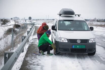 Putting on the snow chains to keep driving along the C-25 near Sant Ramon, in Catalonia.