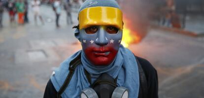 Un joven enmascarado participa en una protesta en Caracas.