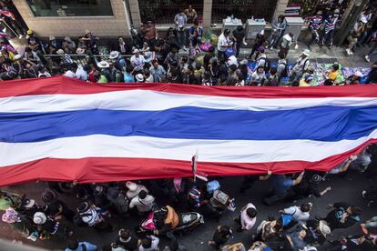 La primera ministra interina se reunió por la mañana con su gabinete y responsables de seguridad en una oficina del Ministerio de Defensa en el norte de la ciudad, desde donde realiza el seguimiento de la protesta. En la imagen, una bandera nacional de tailandia recorre las calles de Bangkok.