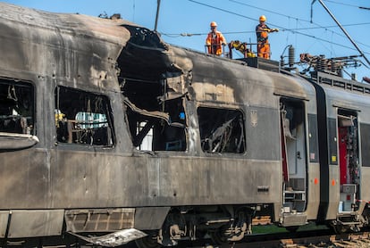 Ferroviarios ucranianos trabajan en un tren de pasajeros de alta velocidad dañado en un ataque ruso en Kiev, el jueves.