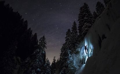 Un escalador asciende una cascada de hielo durante un entrenamiento nocturno cerca de La Lecherette (Suiza), el 14 de febrero de 2018.