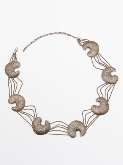Este cinturón de Massimo Dutti va decorado con formas orgánicas que se inspiran en los fósiles y el juego de cadenas crean un efecto envolvente y sofisticado. Está hecho con latón reciclado certificado. (79.95 €)