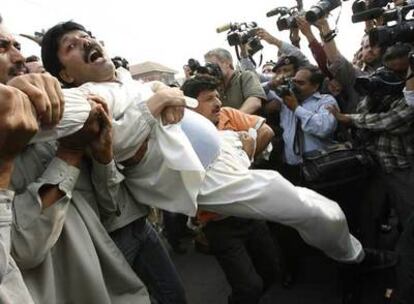 Un partidario de la líder opositora Benazir Bhutto es detenido ayer en Lahore mientras grita contra el general Musharraf.