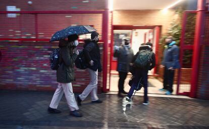 Varios alumnos entran al colegio Arcangel Rafael, en Aluche, el día de la reapertura de los centros educativos tras la gran nevada de 'Filomena'.