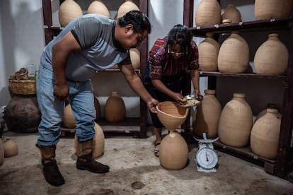 Ixmukané Saloj y su hermano Eduardo Saloj llenan los silos de semillas nativas, en la aldea Chaquijyá, en Guatemala, el 30 de agosto de 2024.