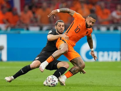 Memphis Depay pugna por el balón con Dragovic