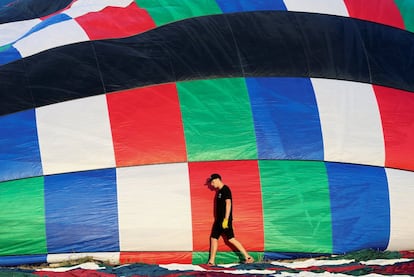 Un hombre camina cerca de un globo aerostático antes de ser elevado durante un evento en Todi (Italia).