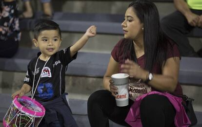 Una madre lleva a su hijo al estadio Olímpico Benito Juárez.