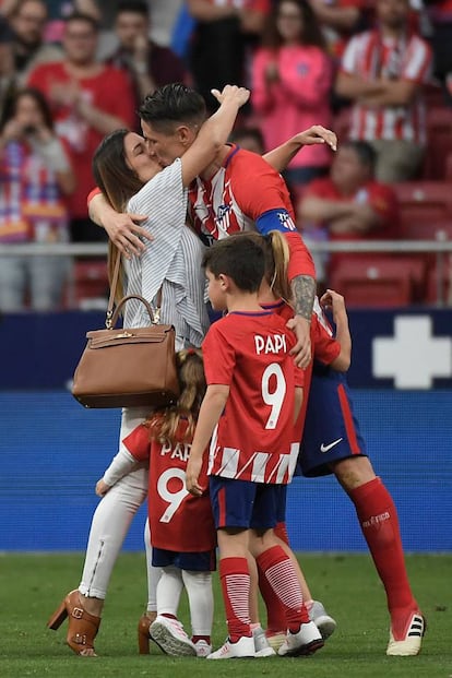 El delantero español del Atlético de Madrid Fernando Torres besa a su esposa Olalla Domínguez junto a sus hijos Nora, Leo y Elsa durante un homenaje al final del partido de fútbol de la liga española entre el Club Atlético de Madrid y SD Eibar en el estadio Wanda Metropolitano de Madrid.