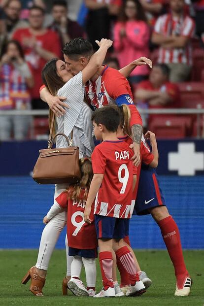 El delantero español del Atlético de Madrid Fernando Torres besa a su esposa Olalla Domínguez junto a sus hijos Nora, Leo y Elsa durante un homenaje al final del partido de fútbol de la liga española entre el Club Atlético de Madrid y SD Eibar en el estadio Wanda Metropolitano de Madrid.