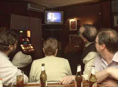 Clientes de un bar siguen un programa de televisión.